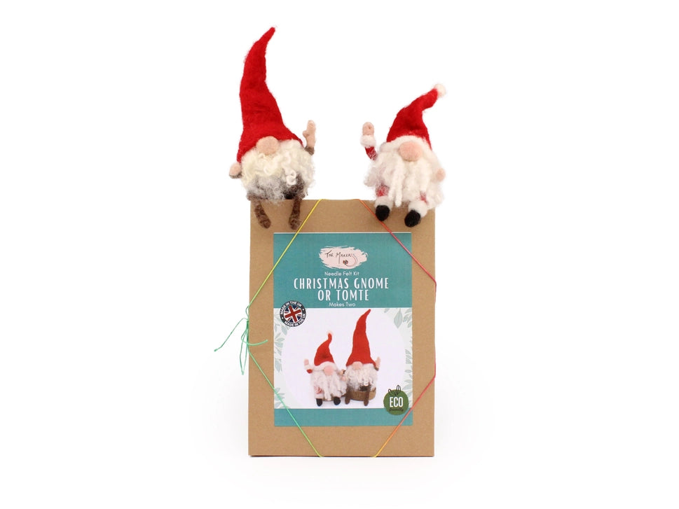 Two Christmas gnomes on top of a box with a label on a white background