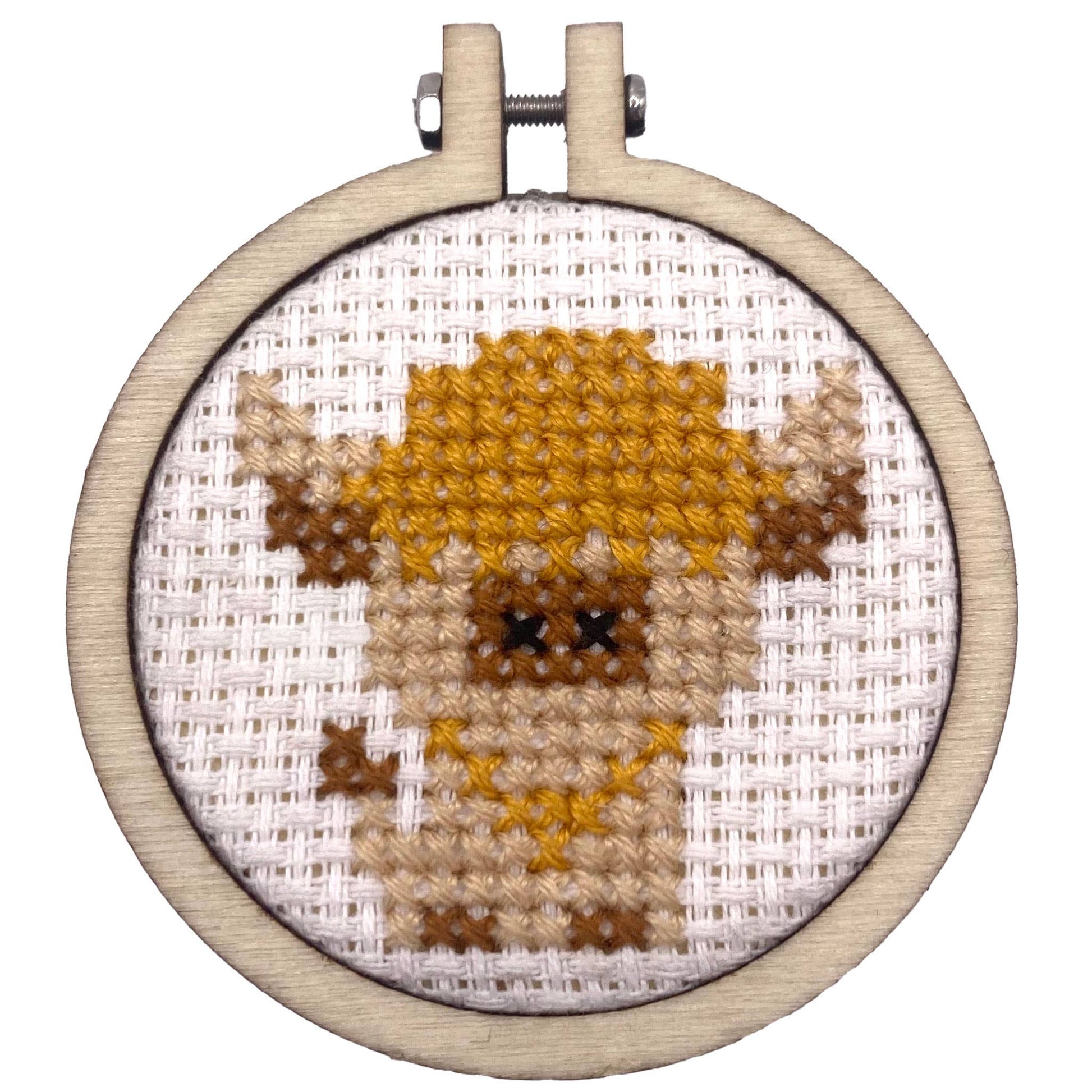 Hoop showing cross stitched highland cow on a white background