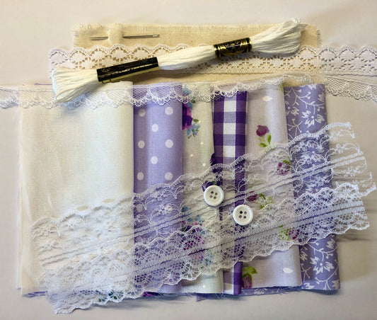 Collection of fabric samples with lace and buttons on a white background