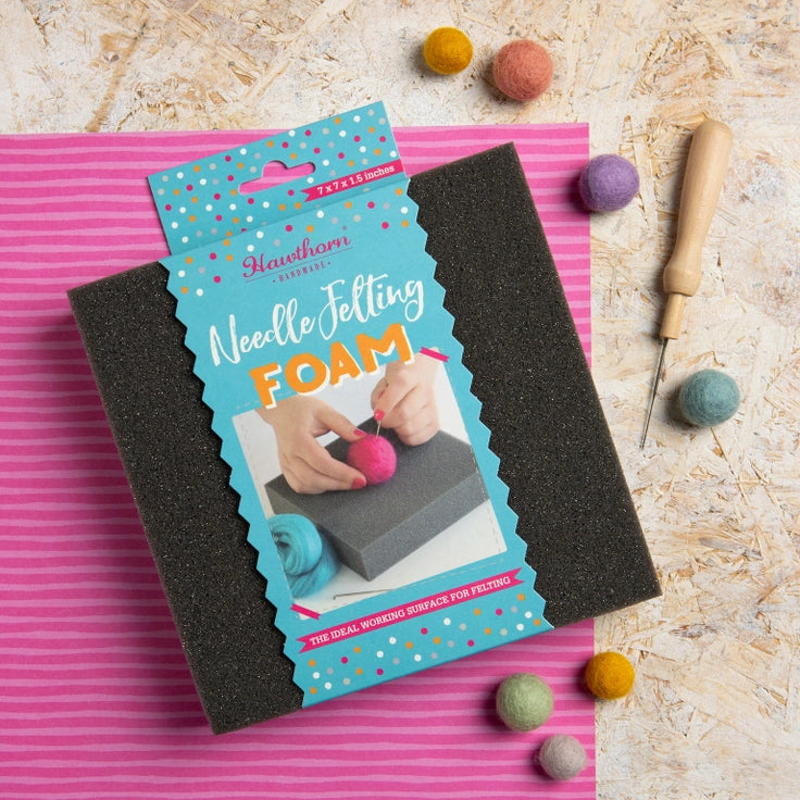 Hawthorn Needle Felting Foam with packaging on a pink mat, surrounded by felting tools and materials.