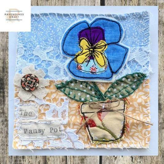 Blue Pansy in a pot on a blue and orange background covered in lace.