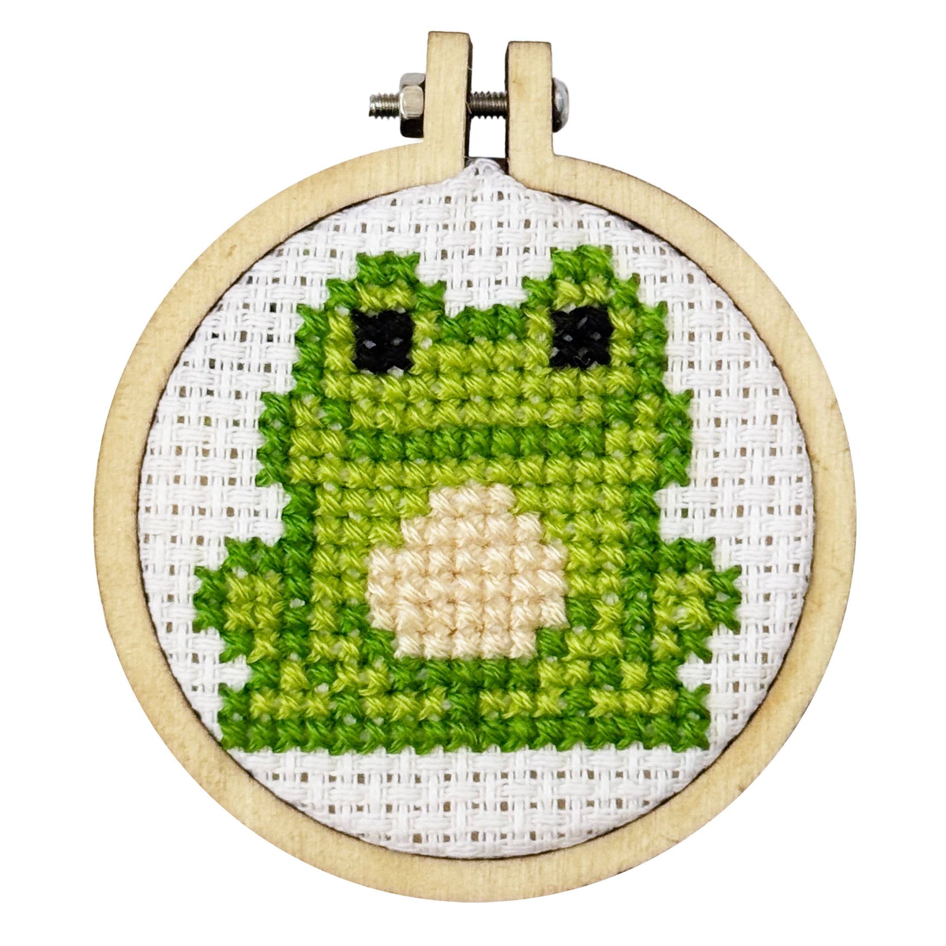 Cross-stitched green character in a wooden hoop on a white background