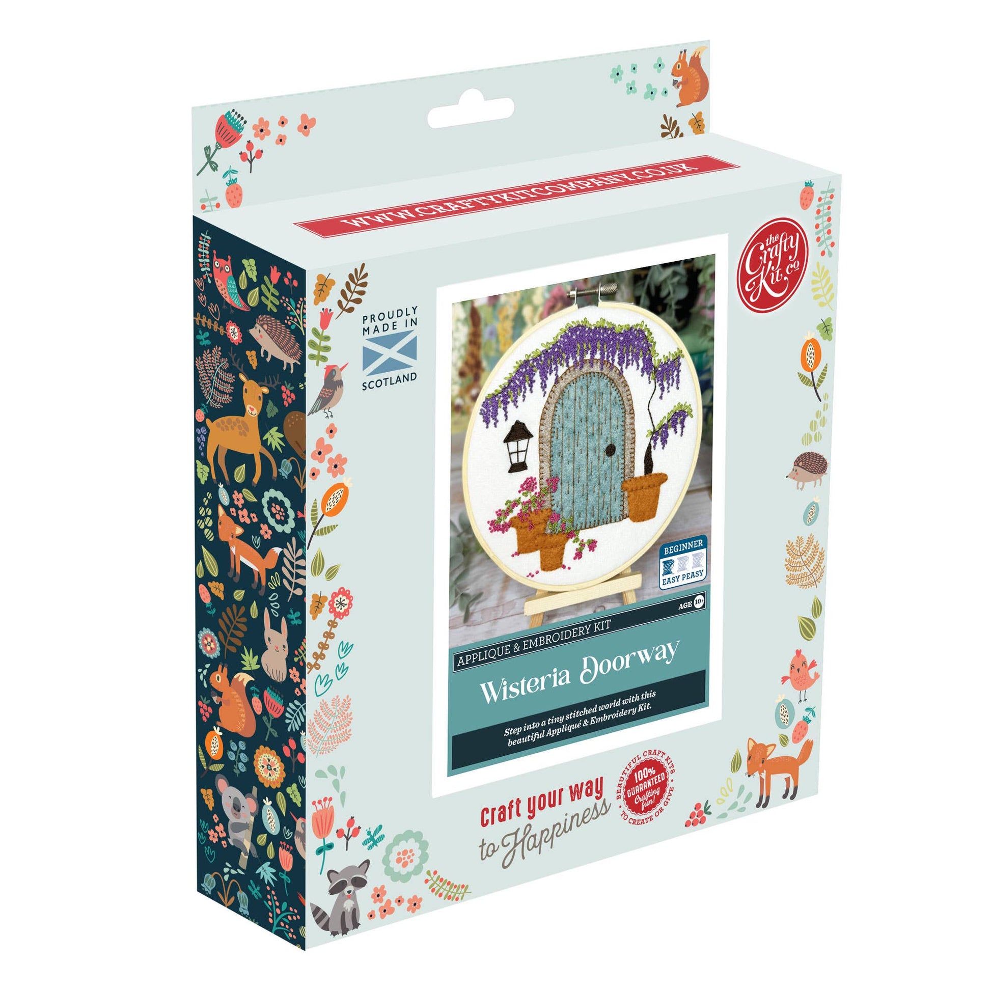 Wisteria Doorway Appliqué and Embroidery Craft Kit box, showing a completed hoop with a felt doorway scene featuring cascading purple wisteria, flower pots and a lantern. Beginner level, made in Scotland.