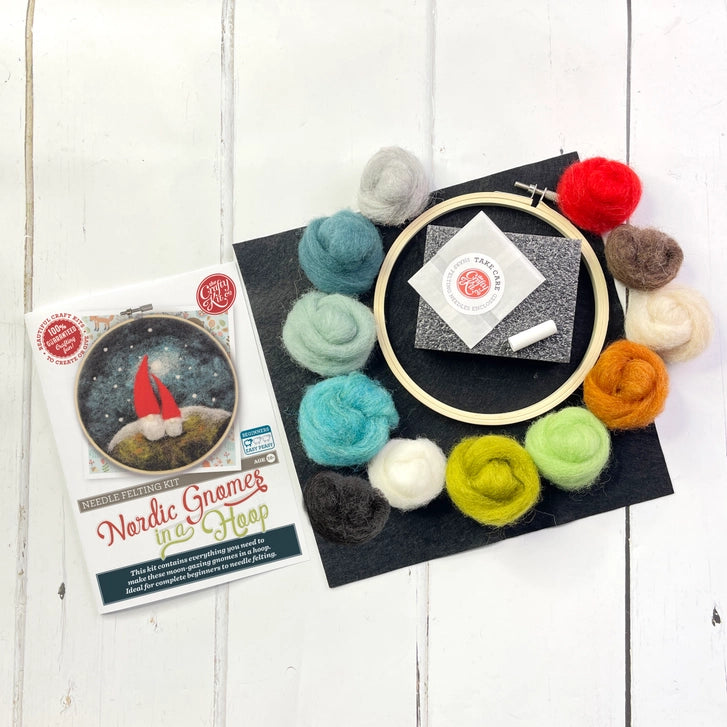 Embroidery hoop with colourful balls of wool  on a wooden surface